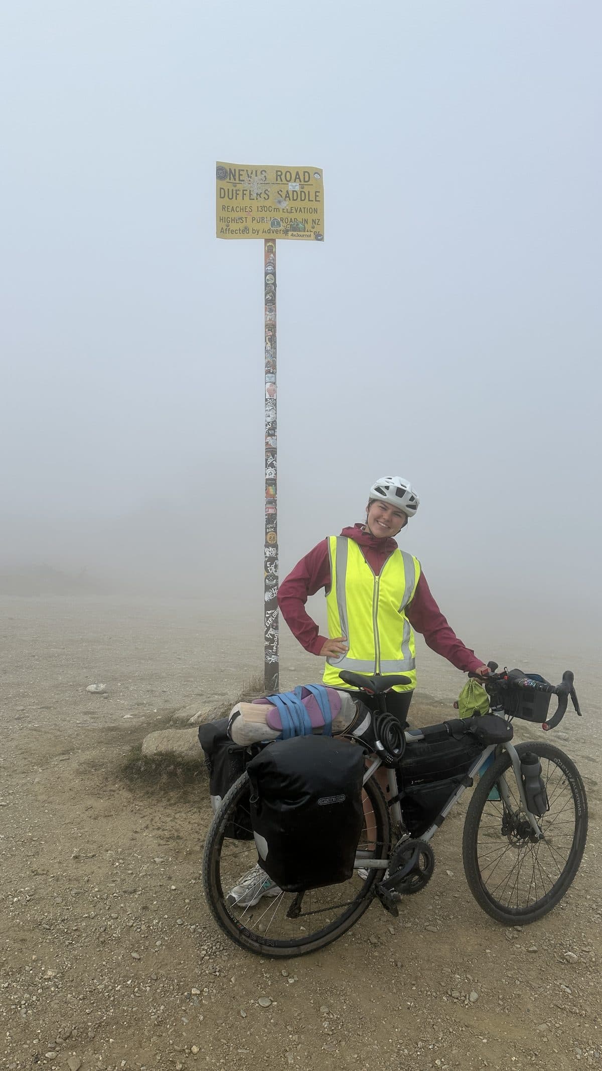 Evgenia with her loaded bike at the Duffers Saddle sign